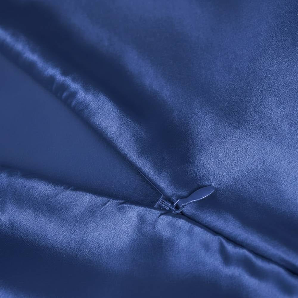 Taie d'oreiller en soie bleu marine avec une texture lisse et brillante, fermée par une petite attache