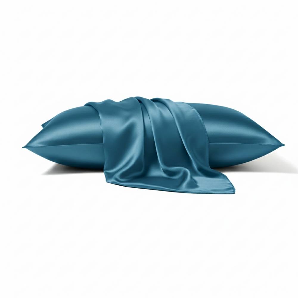 Taie en soie de couleur bleu paon intense avec un drapé élégant sur un coussin