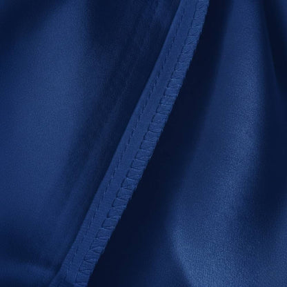 Détail d'une taie d'oreiller en soie bleu marine avec couture visible et texture lisse