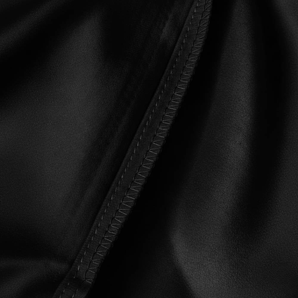 Taie d'oreiller en soie noire avec une texture lisse et des coutures délicates visibles sur l'image