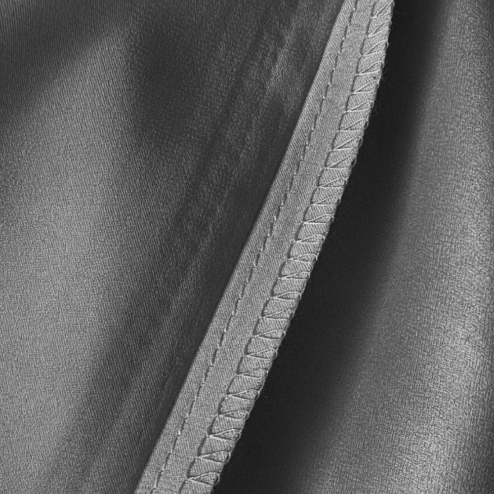 Détail d'une taie d'oreiller en soie gris anthracite avec couture visible sur le bord