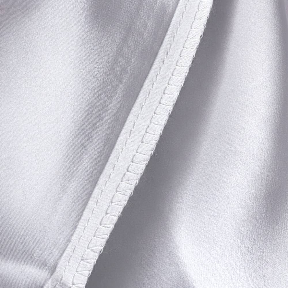 Détail d'une taie d'oreiller en soie de mûrier argenté avec couture soignée et texture lisse