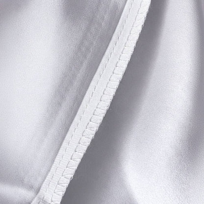 Détail d'une taie d'oreiller en soie de mûrier argenté avec couture soignée et texture lisse