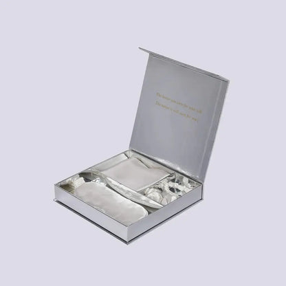 Coffret cadeau en soie blanc ouvert avec taie, masque et chouchou à l'intérieur