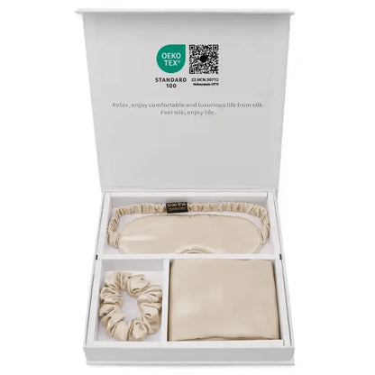Coffret cadeau en soie contenant une taie, un masque et un chouchou beige dans une boîte élégante