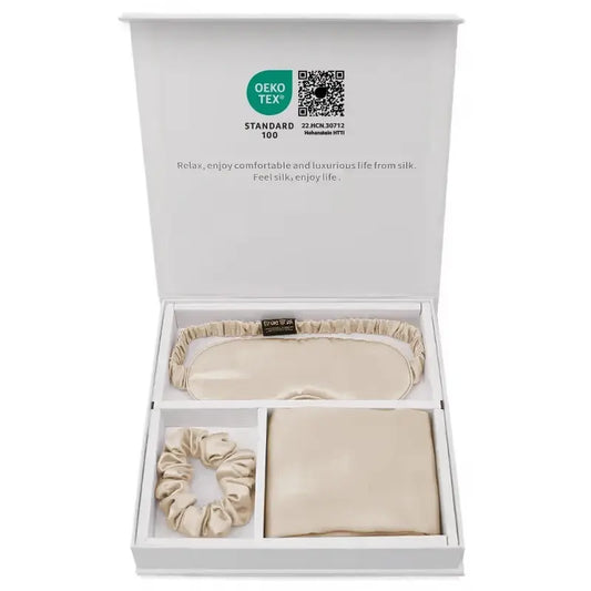 Coffret cadeau en soie contenant une taie, un masque et un chouchou beige dans une boîte élégante